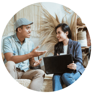 person with laptop talking to another person while sitting down