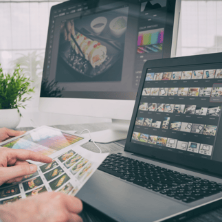 Photographer editing photos on a desktop and laptop